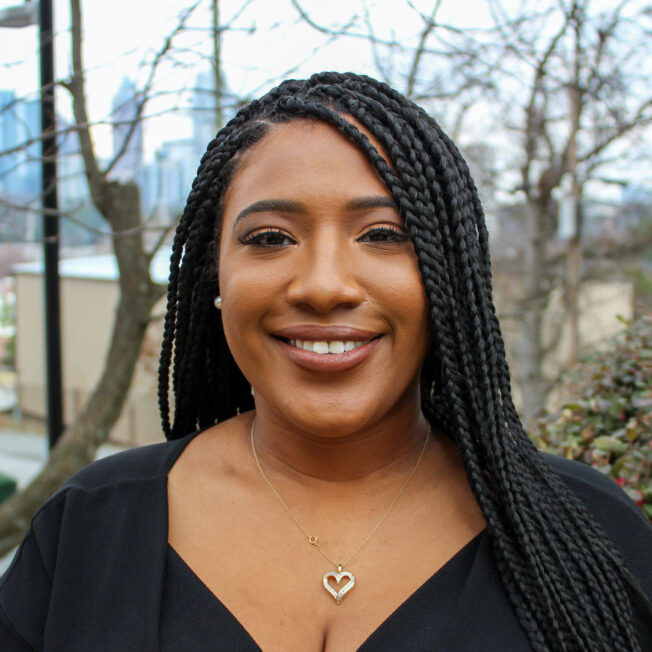 A portrait photo of Shaykara Webster, taken in a park.