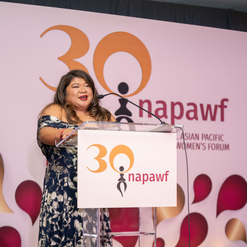 Christina Baal-Owens, a Filipina woman, talking on stage at NAPAWF's 30th Anniversary event.